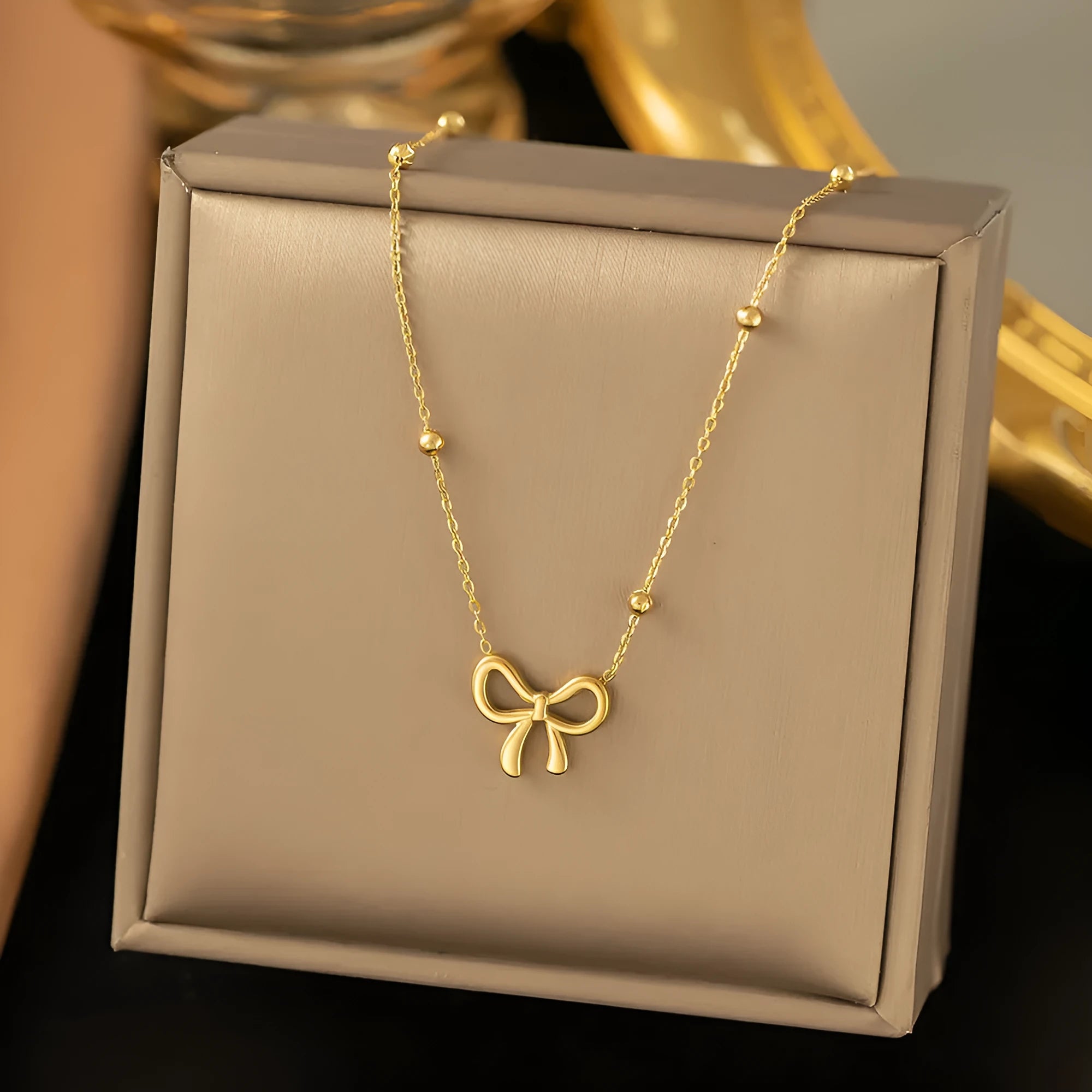 Gold electroplated bow necklace on cross chain with adjustable length