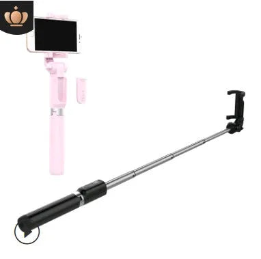 Black Bluetooth selfie stick tripod with extended rod, phone clamp, and deployed legs next to a smartphone