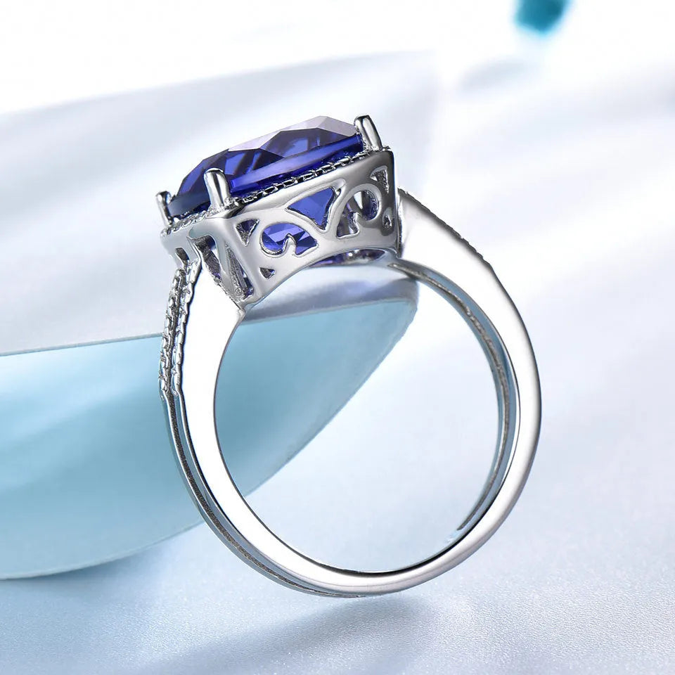 Women's sterling silver ring with a blue Tanzanite gemstone, shown in UK size options 6 to 10.