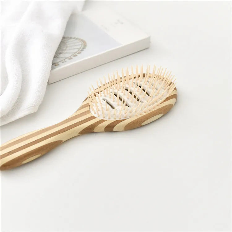 Natural bamboo scalp massage comb with round nylon teeth and rubber pad on neutral background