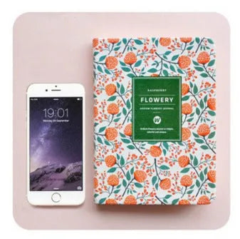 Green fabric imitation leather floral notepad open on a desk, showing custom logo printing and Daolin paper.