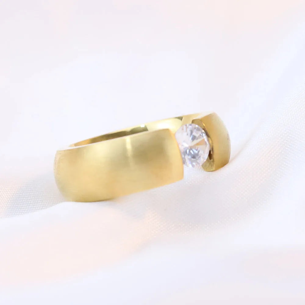 Geometric titanium steel ring with diamond finish in gold colour on a white background