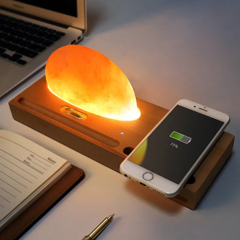 Natural crystal salt lamp with solid beech wood base and integrated Qi wireless phone charging pad.