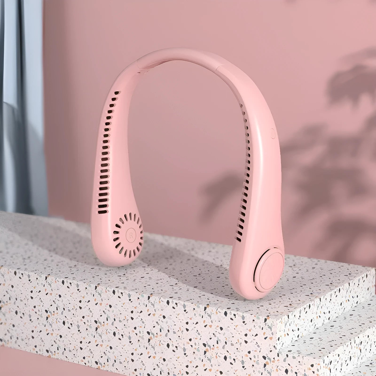 Pink USB rechargeable bladeless neck fan worn around a person's neck.