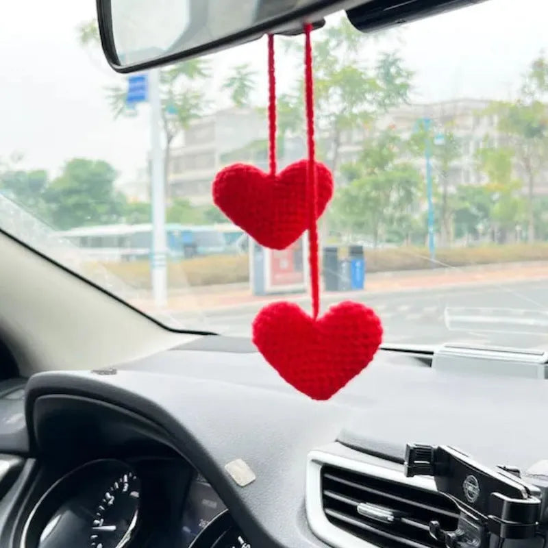 Green and white crochet wool car plant decoration with hanging rope on car dashboard