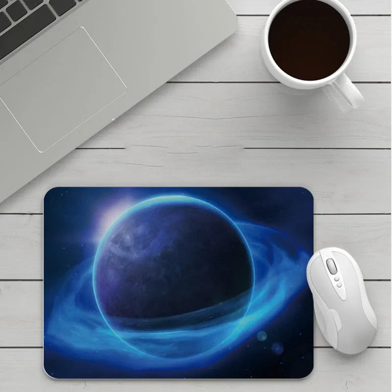 Custom cartoon design on a small black thickened mouse pad with stitching, shown on a desk.