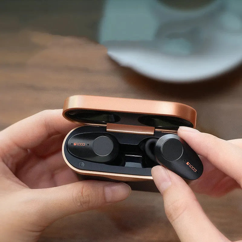 Black wireless Bluetooth headset with charging stand on a table