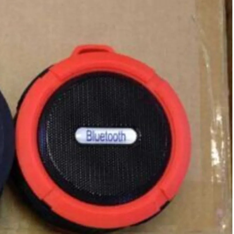 Portable waterproof Bluetooth speaker in multiple colours with a mountaineering buckle for bag attachment.