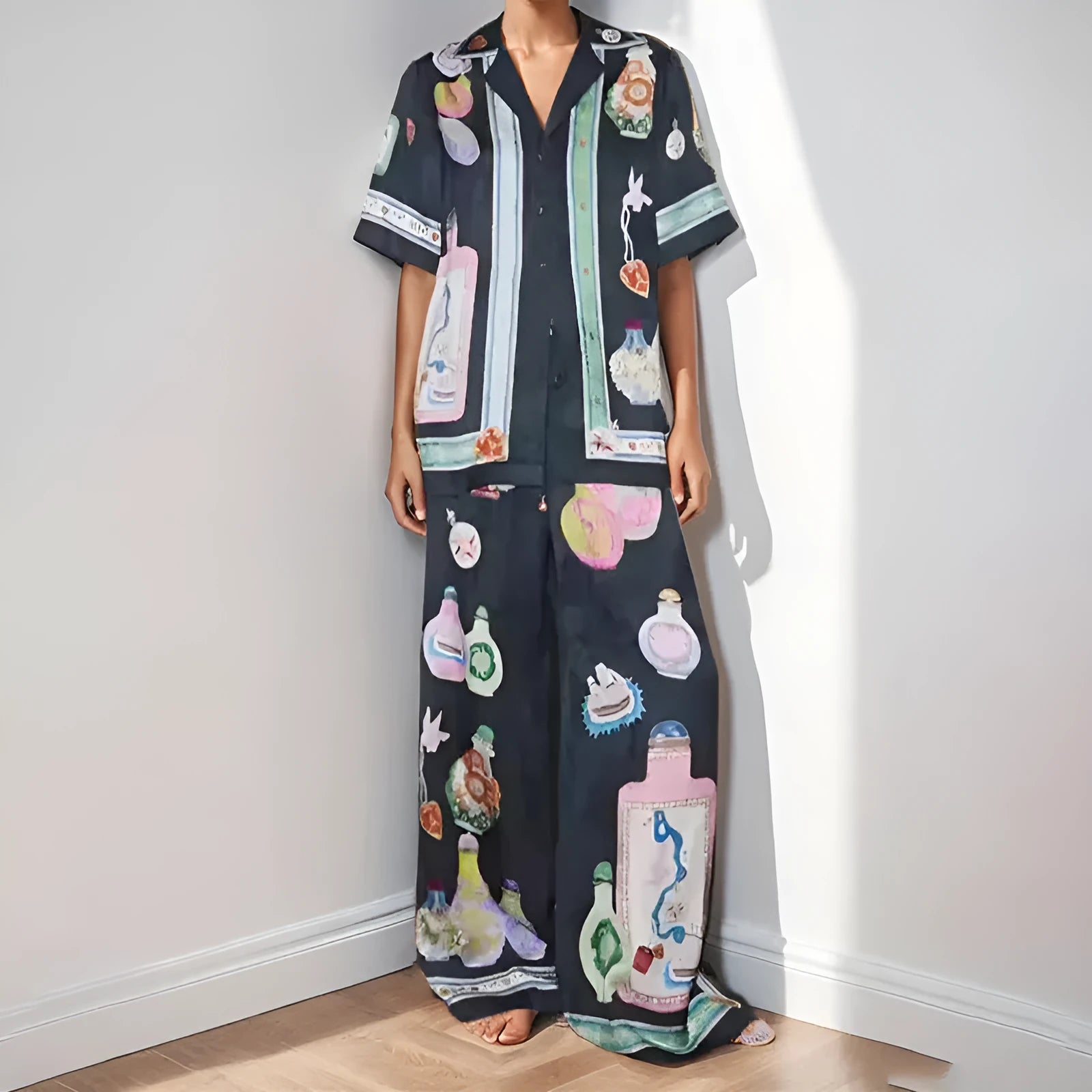 Black women's pyjama set with cartoon print pattern showing matching trousers and top