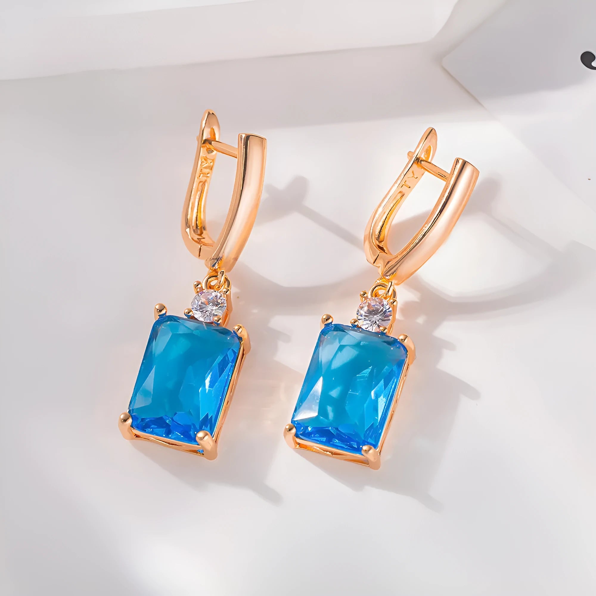 A pair of square geometric earrings with a quadrilateral design in a gold or silver electroplated finish.