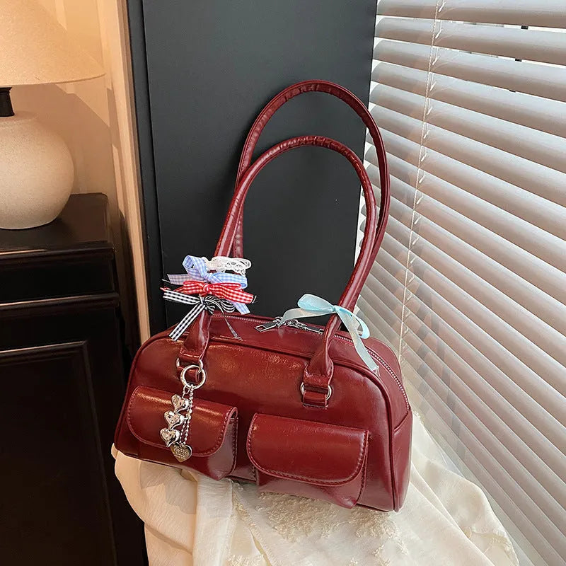 Retro brown PU leather one-shoulder pillow handbag with a flap closure and double straps.