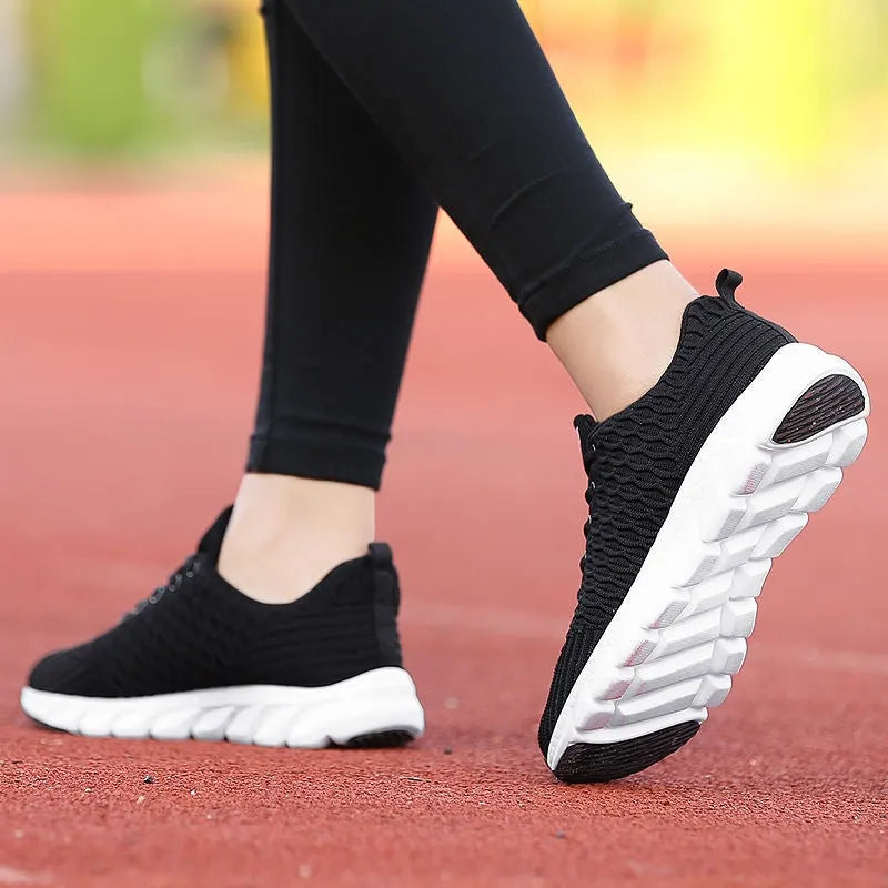 Women's running shoes with a fly weave upper in black, pink, and white colour options on a wear-resistant outsole.