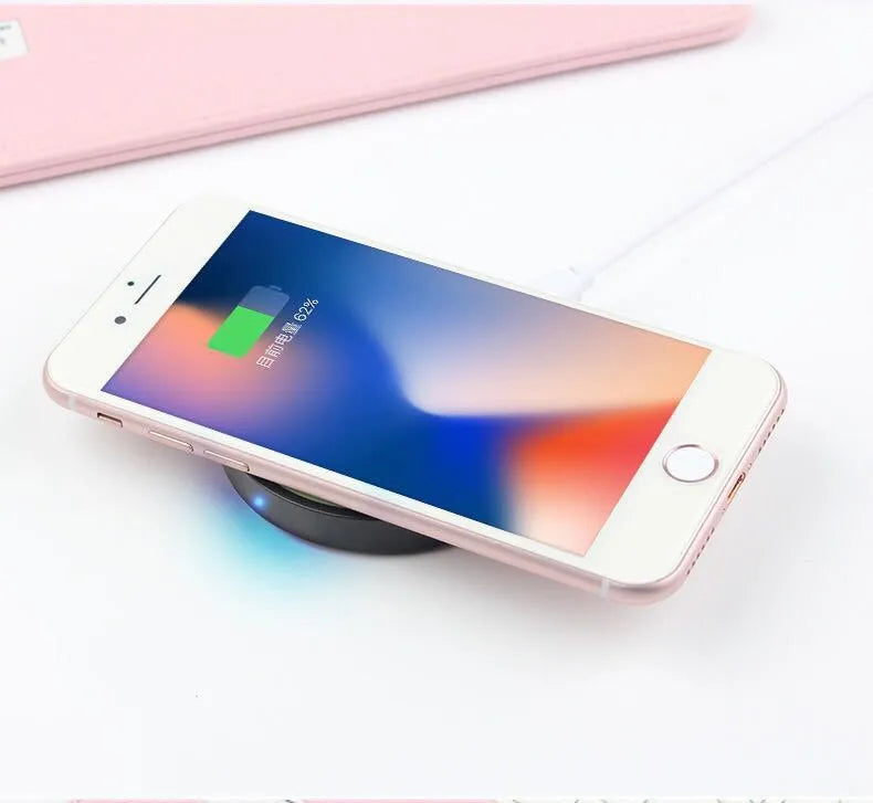 Square Qi wireless charging pad for mobile phones in multiple colours on a desk.