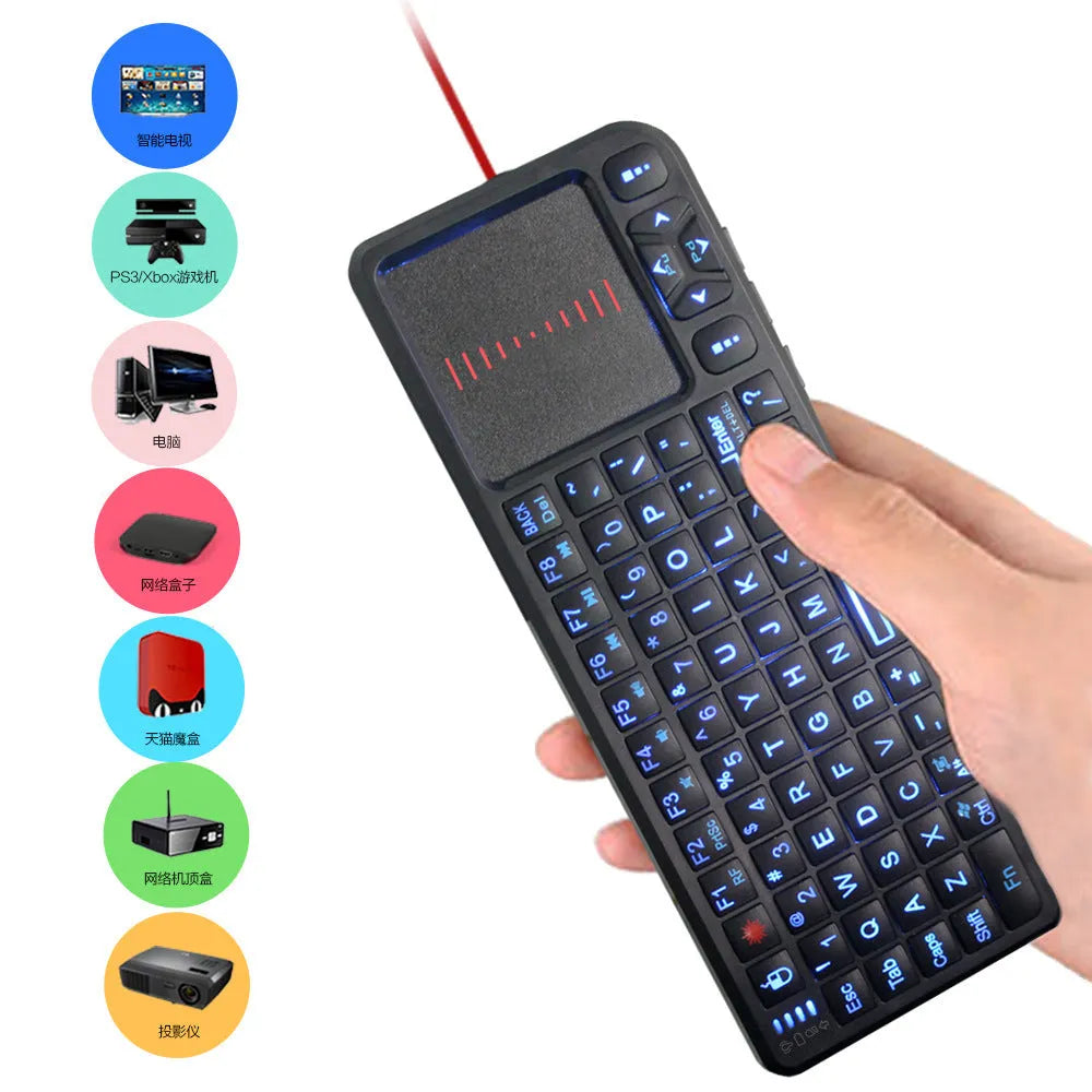 Black wireless laser teaching mini keyboard with touch screen on a desk next to a laptop.