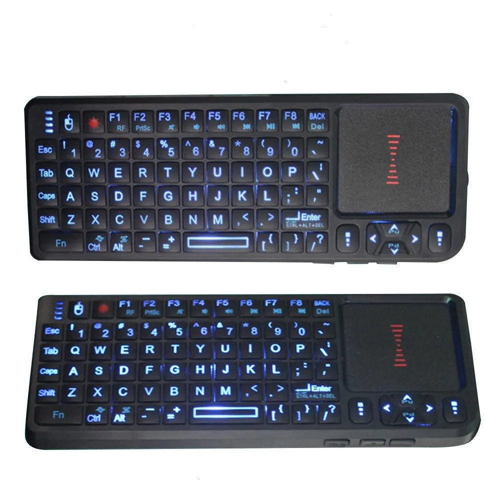 Black wireless laser teaching mini keyboard with touch screen on a desk next to a laptop.
