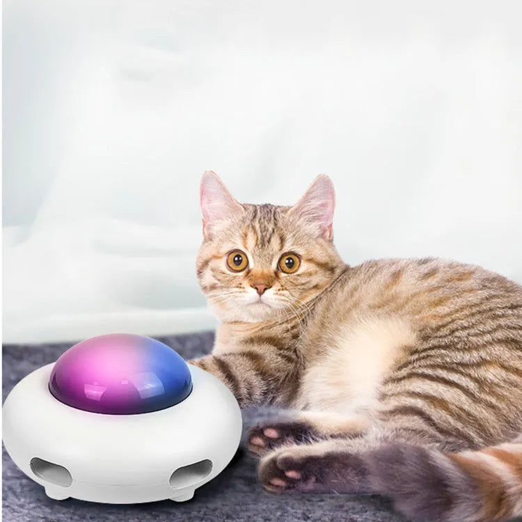White UFO electric cat turntable toy with feather accessories on floor
