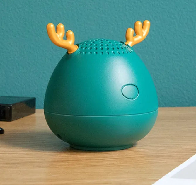 Small green portable Bluetooth speaker with USB charging port on a white background.