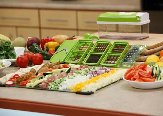 Green 12-piece manual vegetable chopper set with stainless steel blades on a kitchen counter.