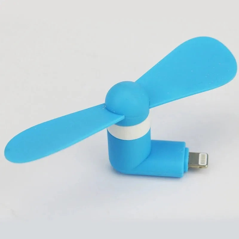 White portable mini fan with plastic blades and rotary switch attached to a mobile phone.