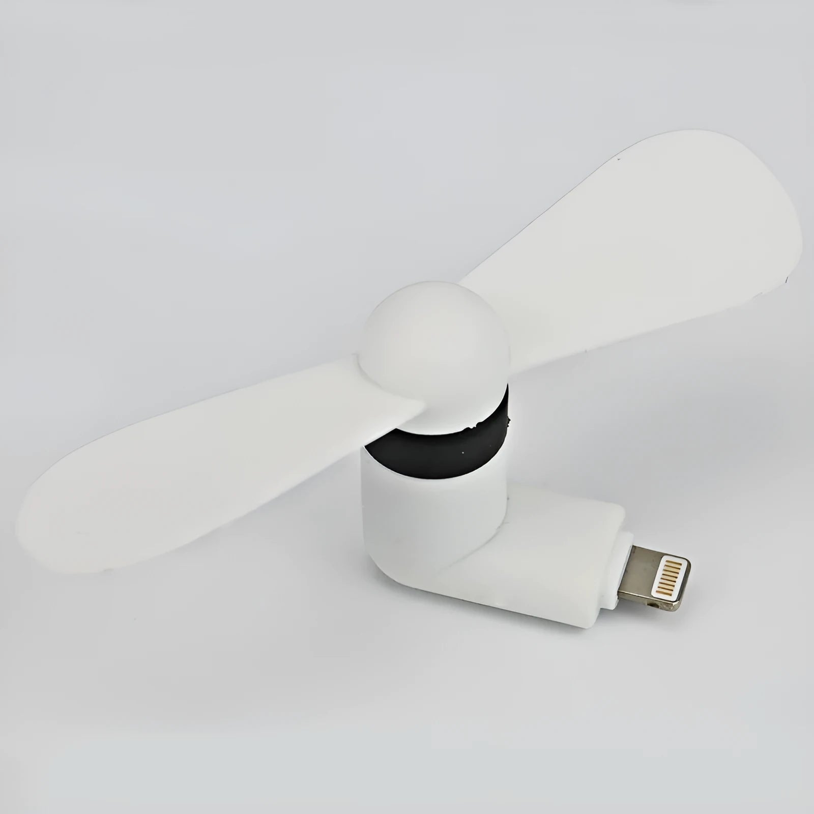 White portable mini fan with plastic blades and rotary switch attached to a mobile phone.