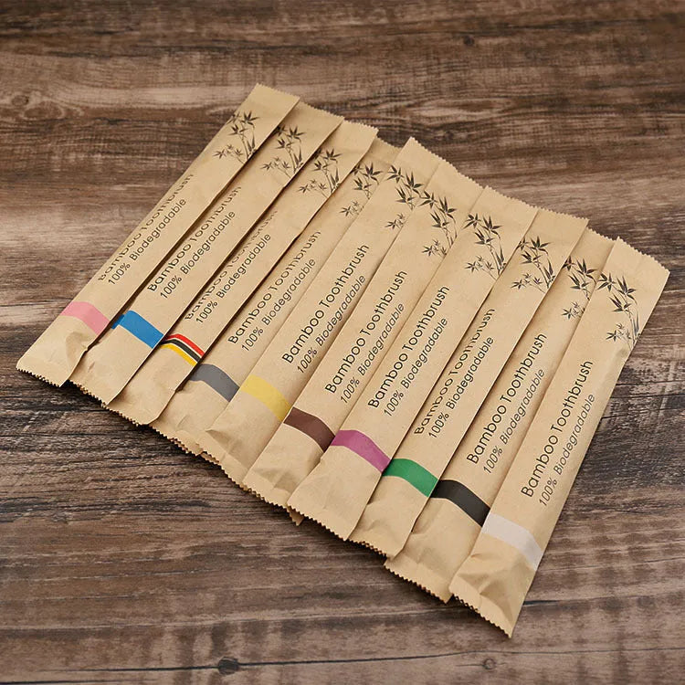 Set of ten bamboo toothbrushes with charcoal-infused bristles in assorted colours on a white background.
