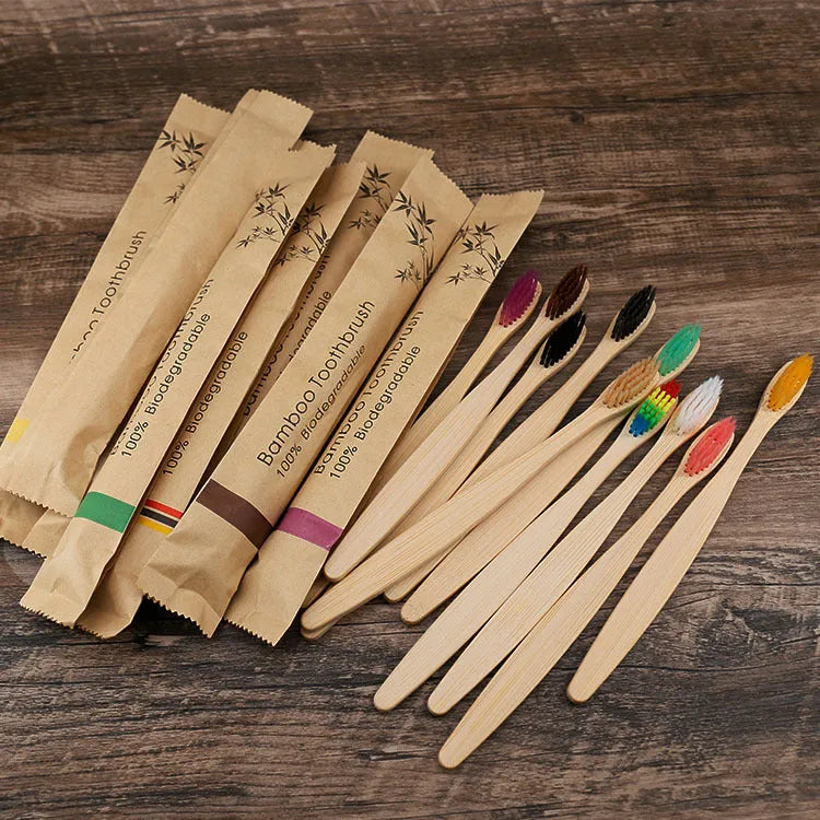 Set of ten bamboo toothbrushes with charcoal-infused bristles in assorted colours on a white background.