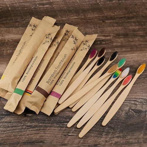 Set of ten bamboo toothbrushes with charcoal-infused bristles in assorted colours on a white background.