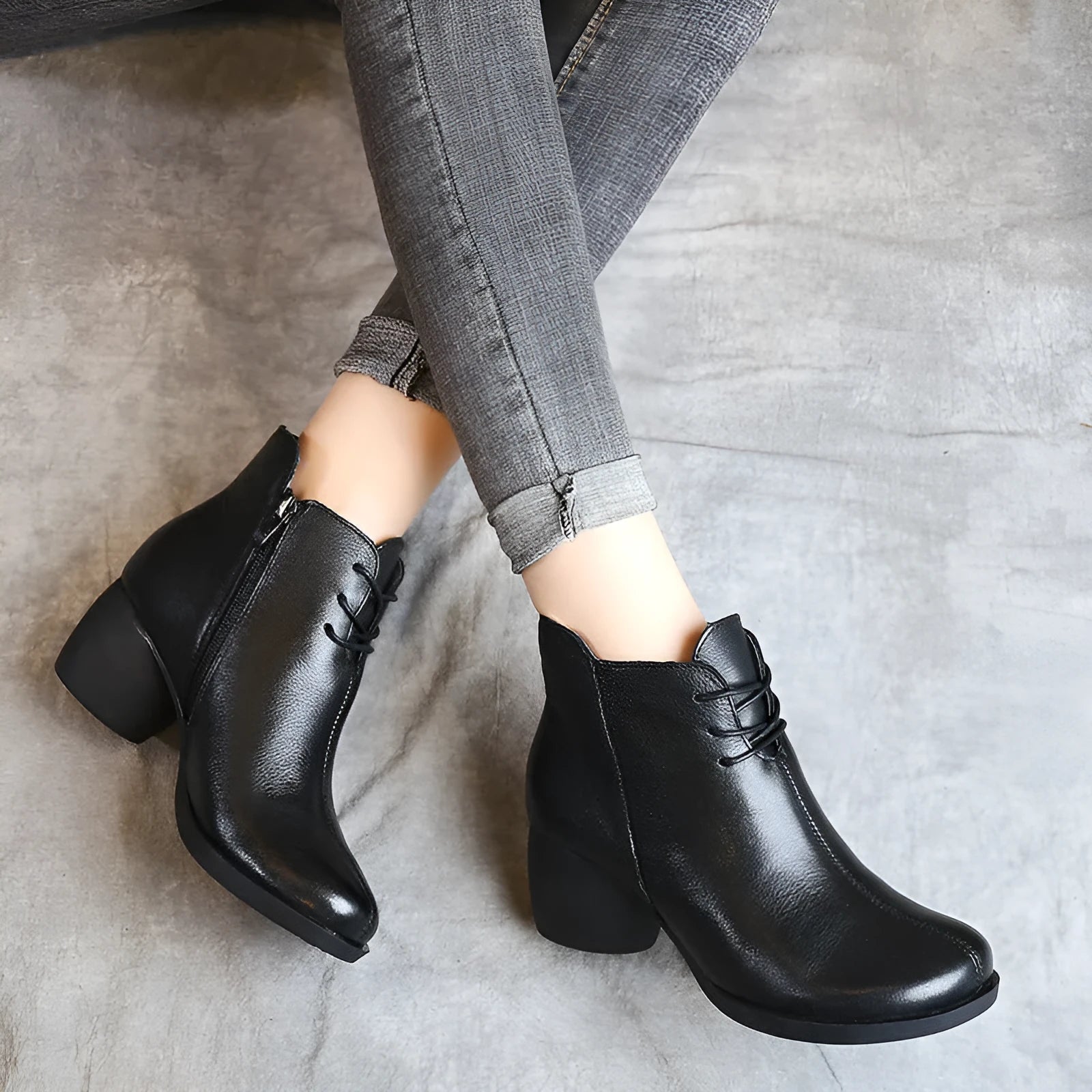 Brown women's leather Martin boots with a thick round heel and round toe on a wooden floor.