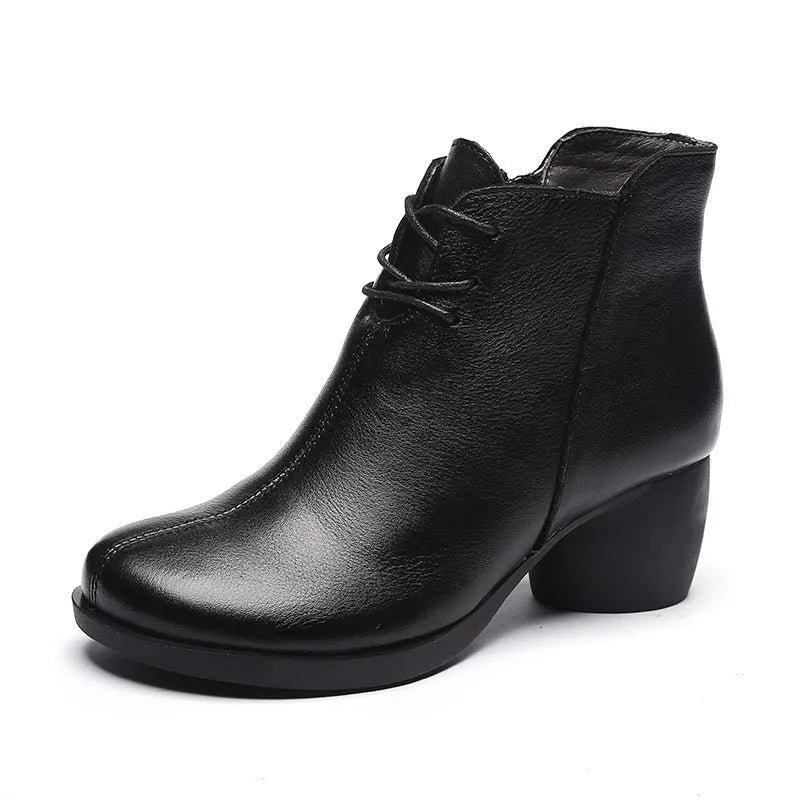 Brown women's leather Martin boots with a thick round heel and round toe on a wooden floor.