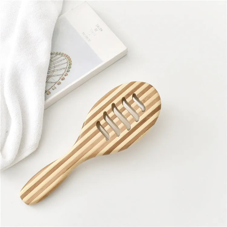 Natural bamboo scalp massage comb with round nylon teeth and rubber pad on neutral background