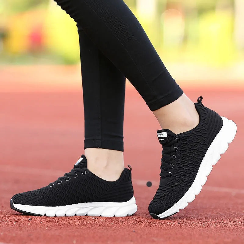 Women's running shoes with a fly weave upper in black, pink, and white colour options on a wear-resistant outsole.
