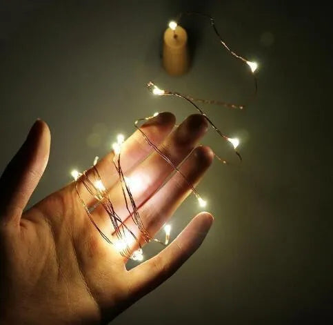 Copper wire LED string light with 20 bulbs and a white plastic bottle stopper for decoration.