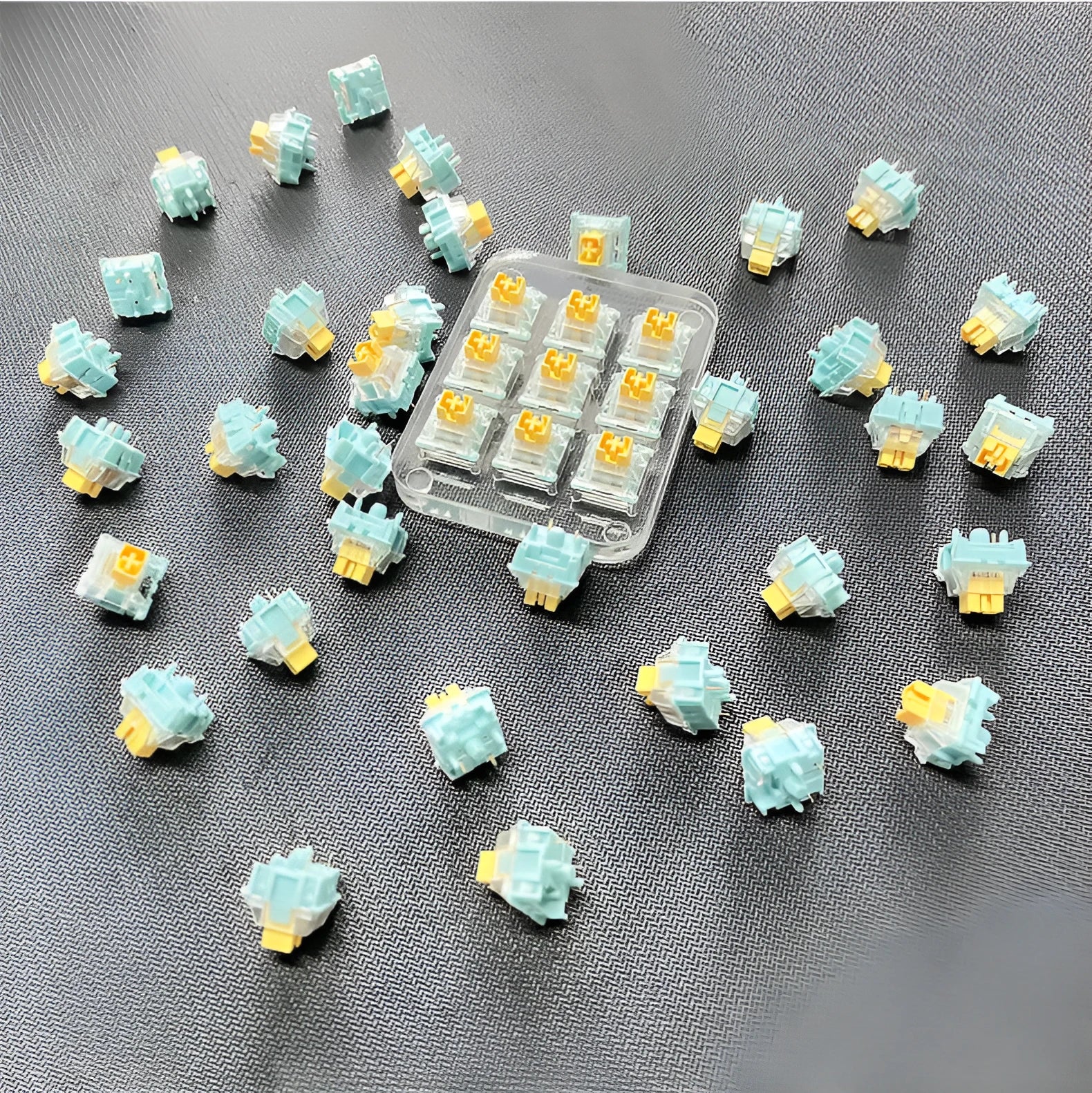 36 Sea Salt Lemon PRO Mute coloured mechanical keyboard switches laid out in rows.