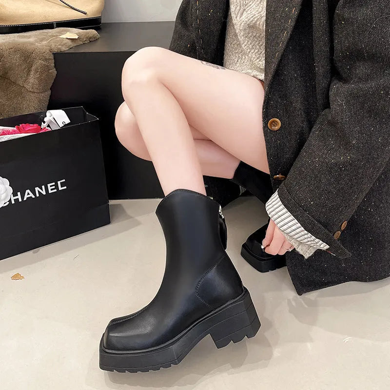 Black women's platform Martin ankle boots with a square toe, high heel, and back zipper on a white background.