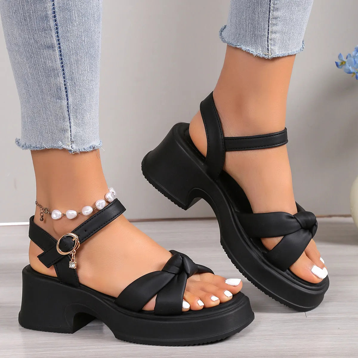 Women's black thick-heel slippers with a button fastening and round toe on a rubber sole.