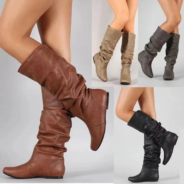 Women's black flat slip-on boots with round toe and high ankle shaft.