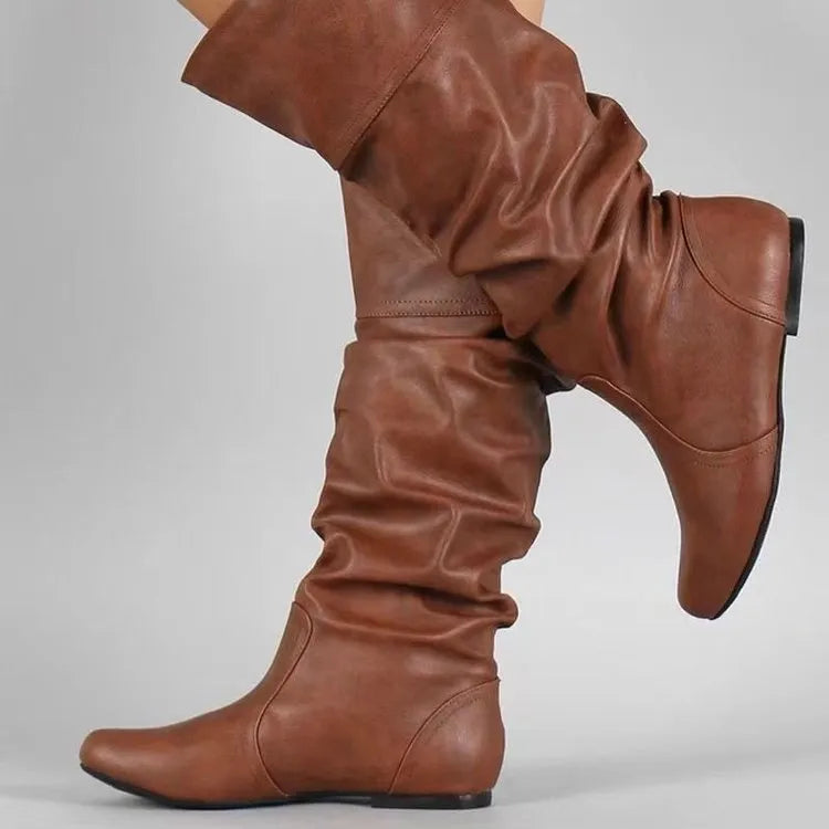 Women's black flat slip-on boots with round toe and high ankle shaft.