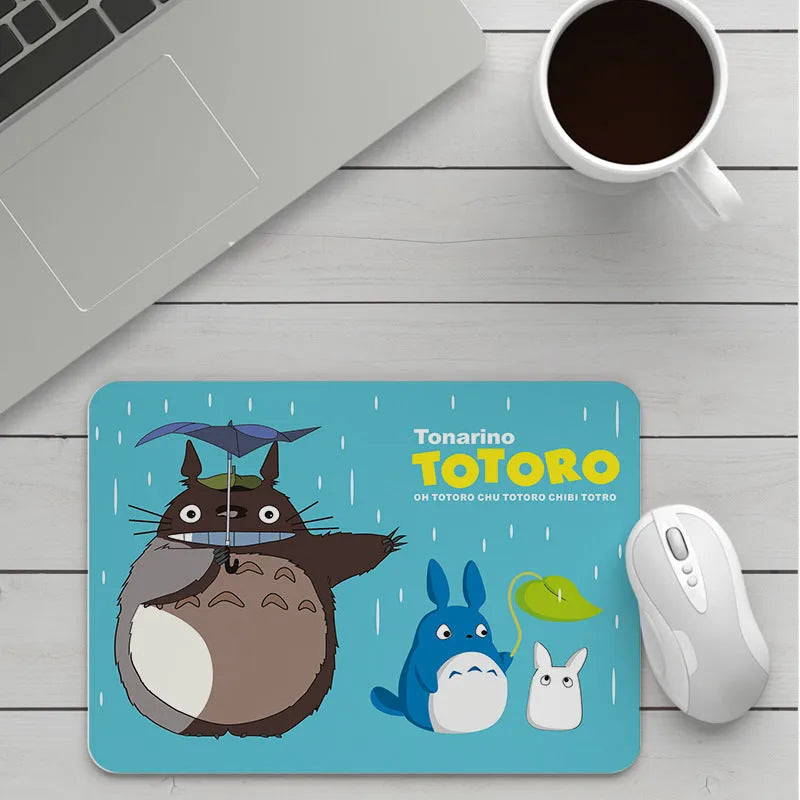 Custom cartoon design on a small black thickened mouse pad with stitching, shown on a desk.