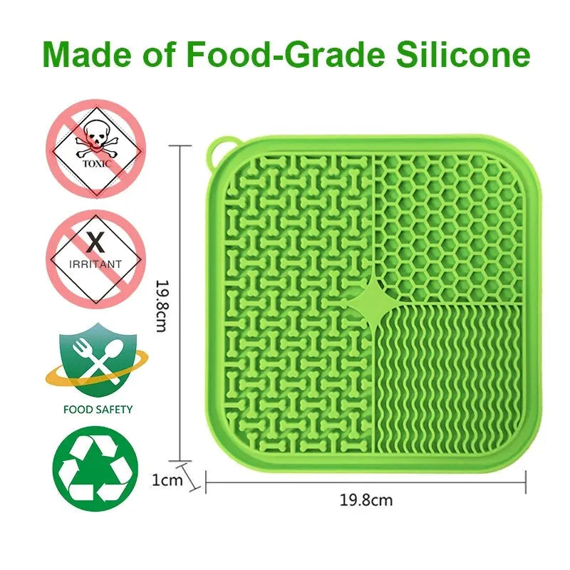 Orange, grey, blue, and green silicone dog licking mat with suction cups on a smooth surface.