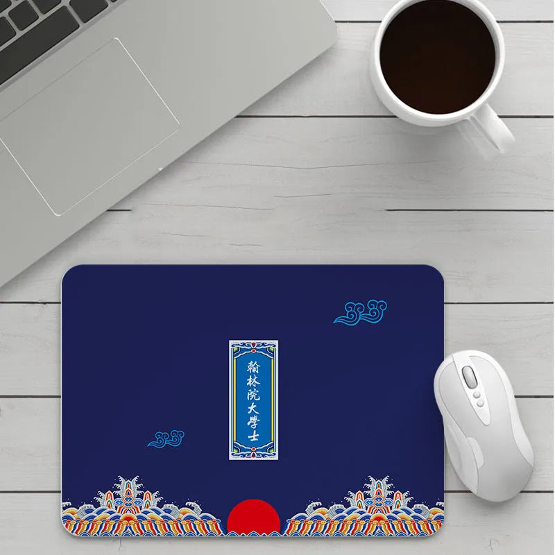 Custom cartoon design on a small black thickened mouse pad with stitching, shown on a desk.