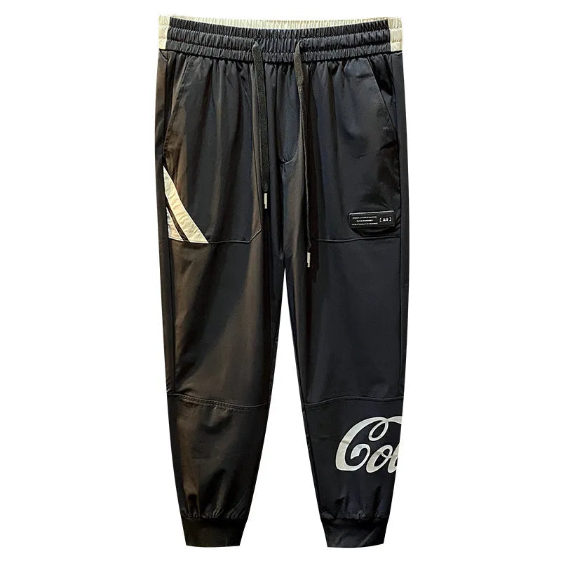 Men's solid black cotton trousers with elasticated ankle bands, shown in a casual style.