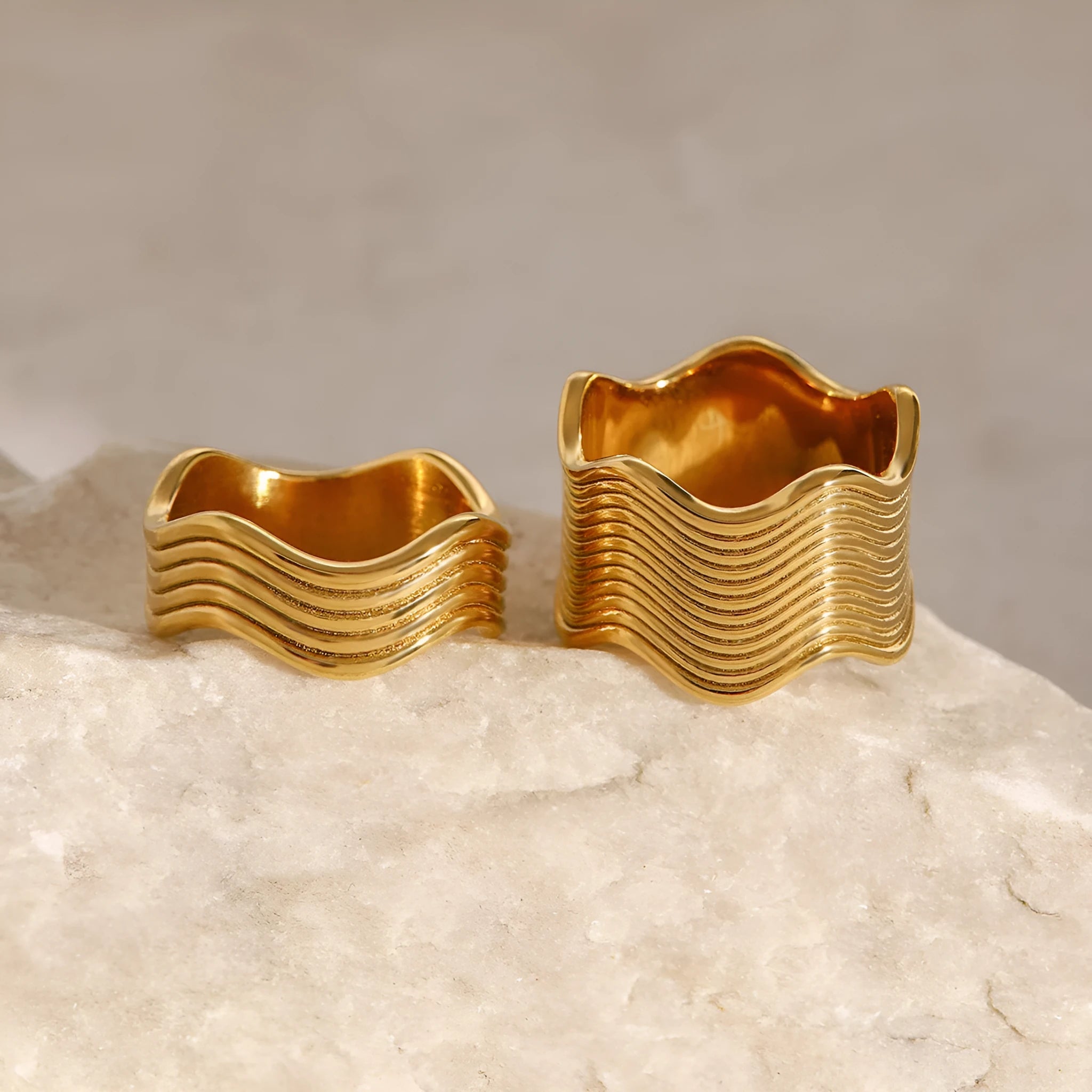 Stainless steel wide band ring with a geometric wave pattern design in an electroplated finish.