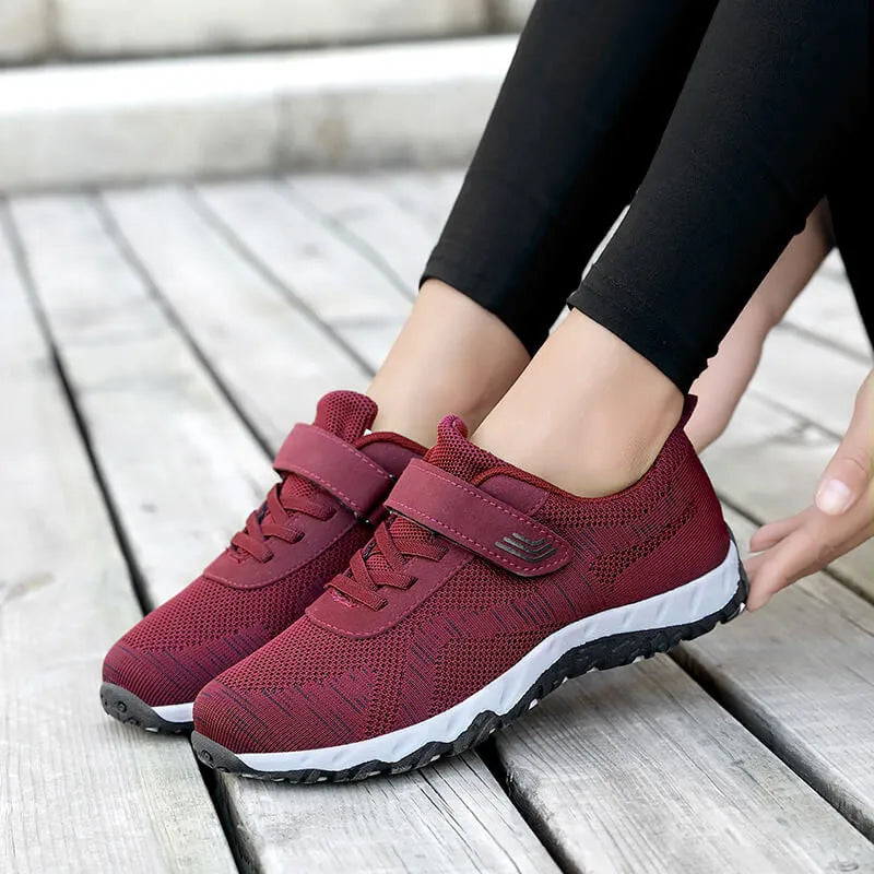 Women's low-top sneakers with Velcro straps and a wedge heel, in a mesh upper and solid colour.