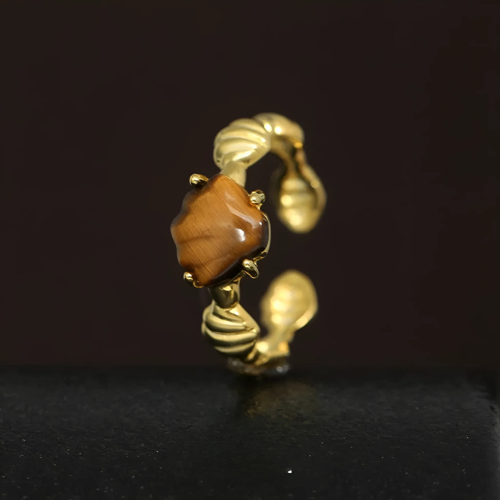 Silver adjustable ring with a tiger eye shell design and gold electroplated finish.