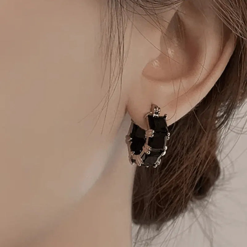 Geometric U-shaped gold earrings with black zircon crystal stones and round decorative elements