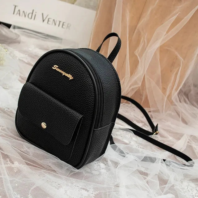 Women's small black PU leather backpack shoulder bag showing front zipper and dimensions
