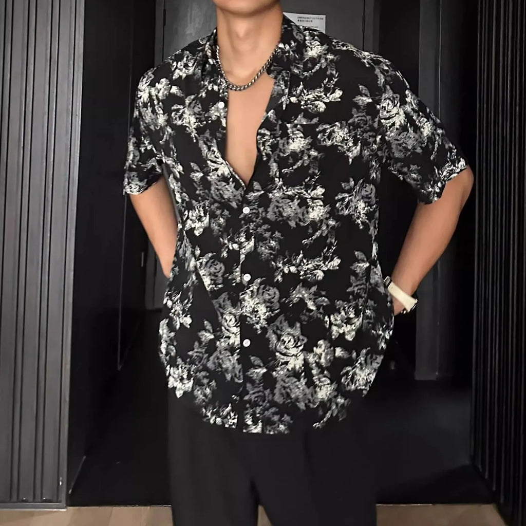 Man's loose fit black short sleeve shirt with floral pattern, worn open in cardigan style.
