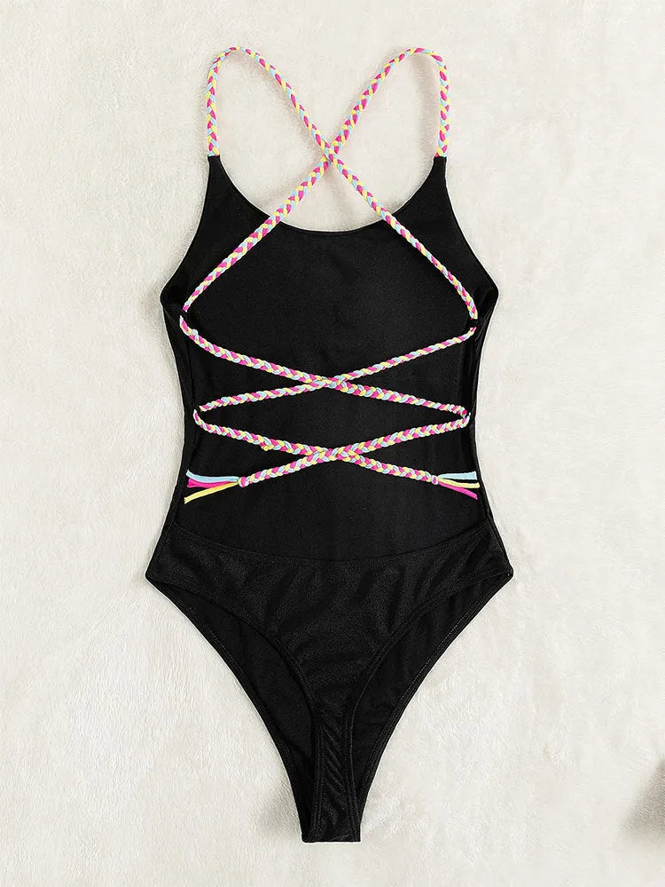 Black women's one-piece swimsuit with a backless and sleeveless design on a mannequin.