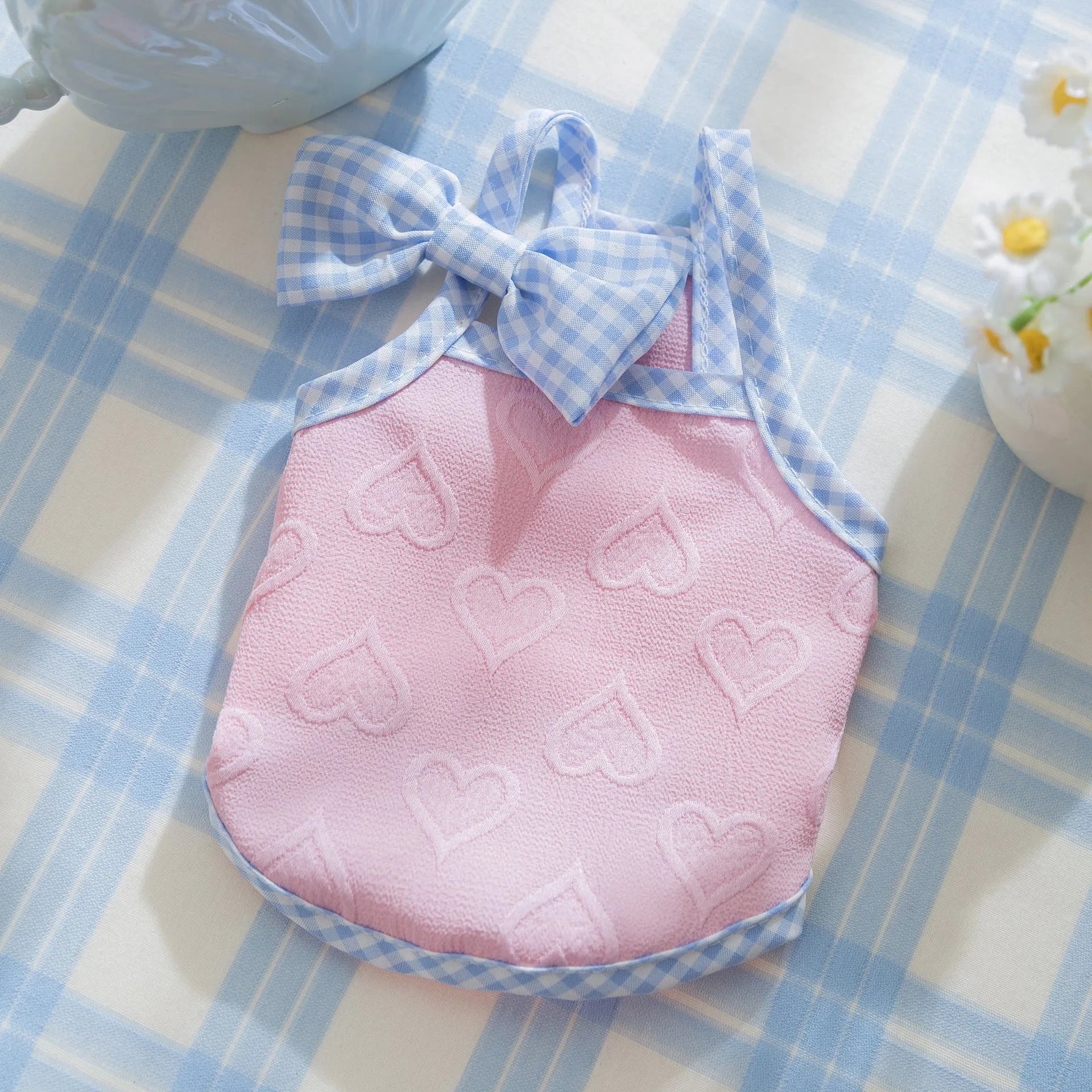 Small dog wearing heart bow suspenders vest in elastic material with decorative bow detail