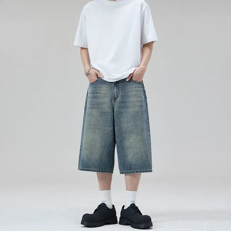 Man wearing straight-leg light blue denim shorts, showcasing the cropped length and loose casual fit.